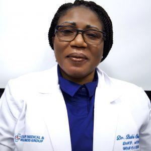 Portrait of Dr. Buki Obasanya, founder of Collin Medical & Wellness Group, wearing a white medical coat and glasses, smiling confidently.