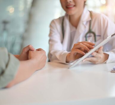 A healthcare provider discusses a weight loss plan with a patient using a digital tablet.
